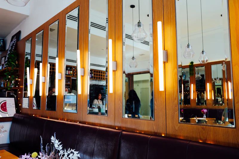 Warm timber, mirrored walls and leather banquettes in a contemporary restaurant.